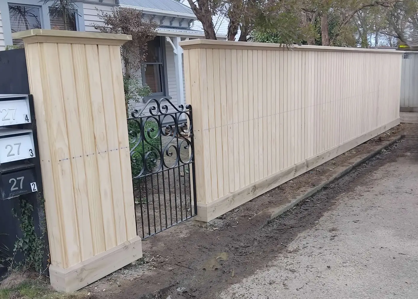 Shiplap timber fence with a wrought iron pedestrian gate